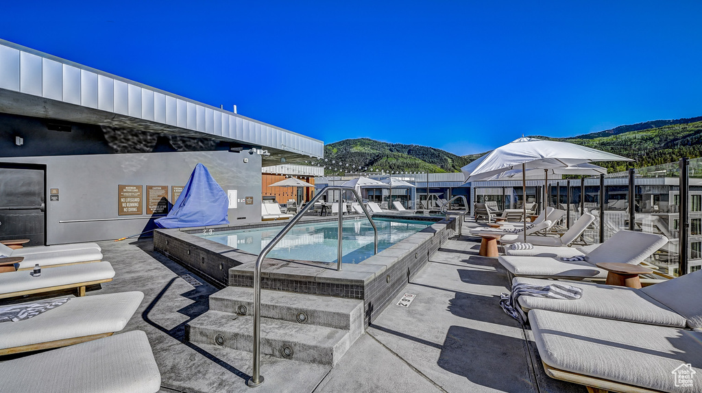 Community pool with a mountain view and a patio area