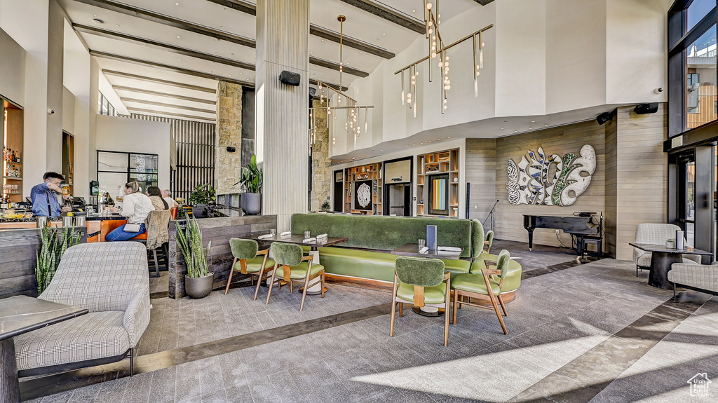 Common area with a towering ceiling and beam ceiling