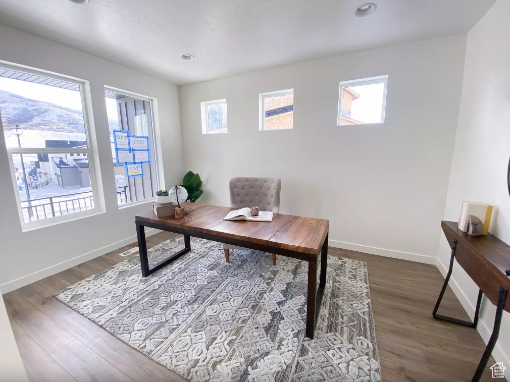 Office with wood finished floors and recessed lighting