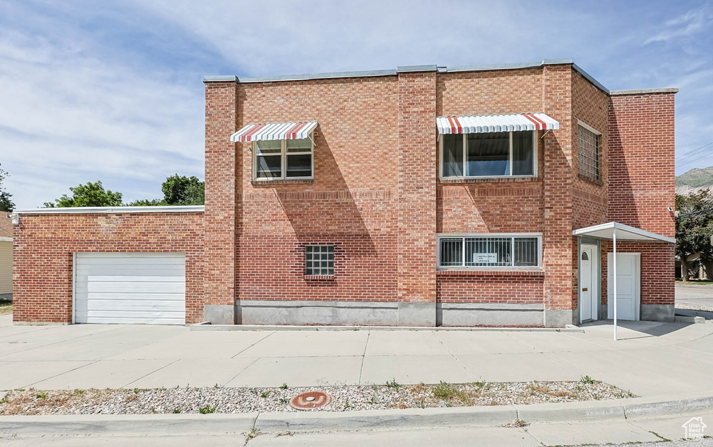View of property featuring an attached garage and concrete driveway