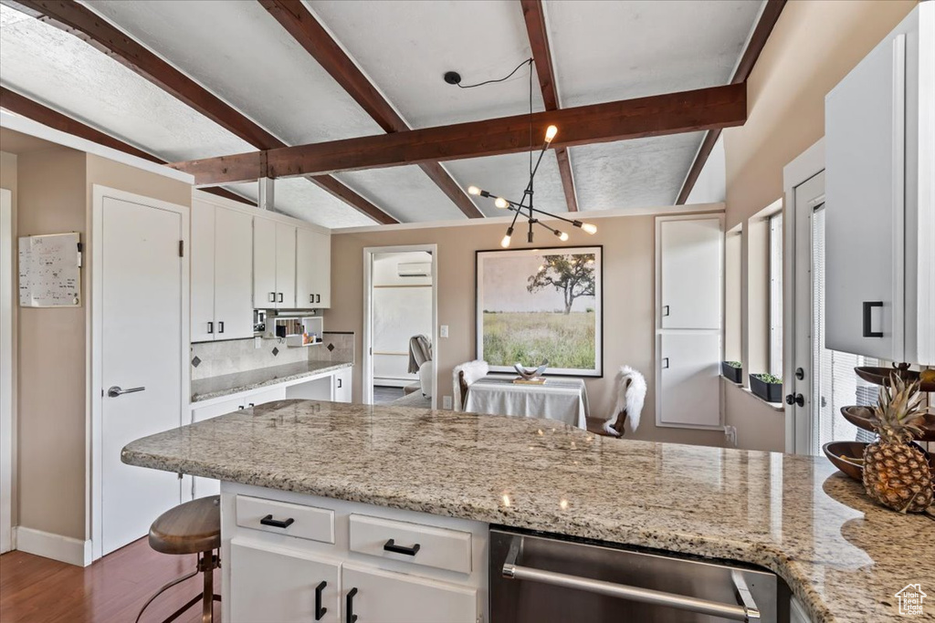Kitchen with stainless steel dishwasher, backsplash, white cabinetry, dark wood-style flooring, and light stone counters