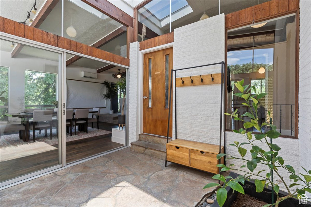 Entrance to property with outdoor dining space and a wall mounted AC