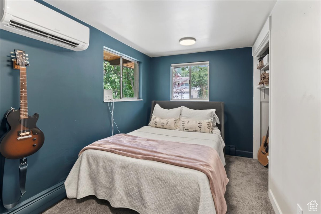 Bedroom featuring a wall unit AC and carpet floors