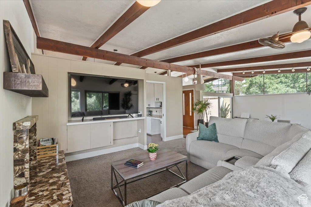 Carpeted living room with beam ceiling and baseboards