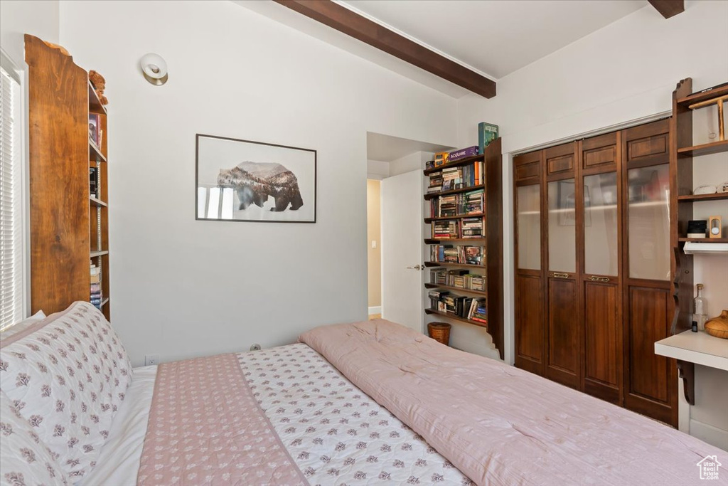 Bedroom with beamed ceiling and a closet