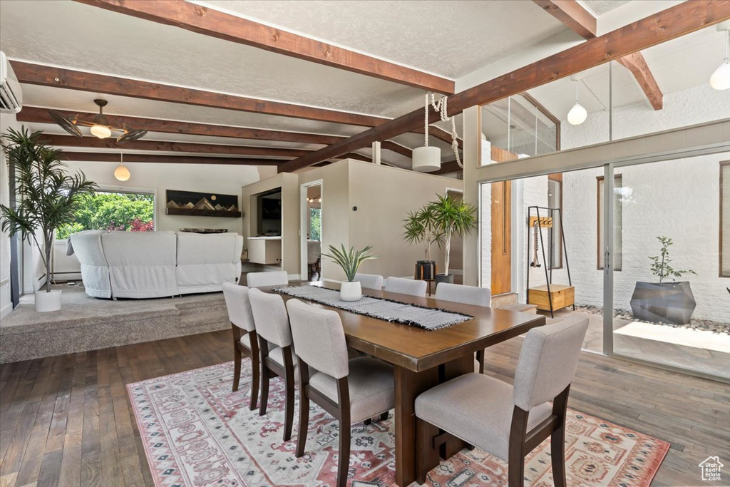 Dining area featuring dark wood finished floors, beam ceiling, and a wall mounted AC