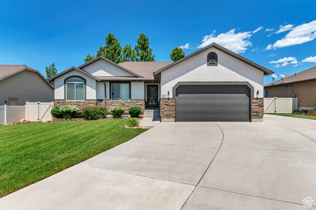 Single story home with stucco siding, concrete driveway, an attached garage, and a gate
