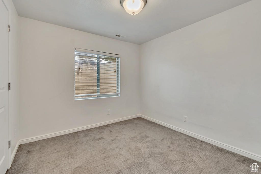 Carpeted empty room featuring baseboards