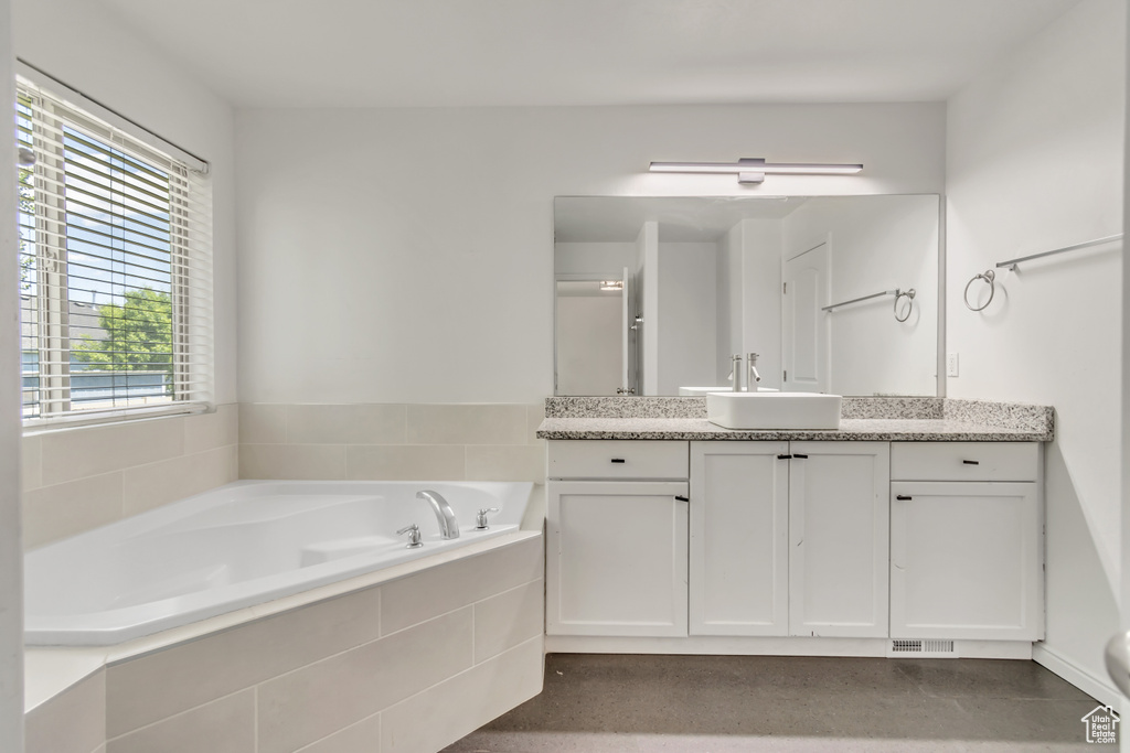 Full bath with vanity and a garden tub