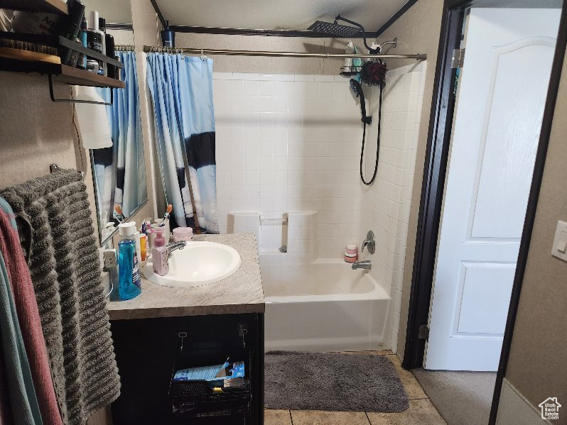 Full bath with shower / bath combination with curtain, vanity, and tile patterned flooring