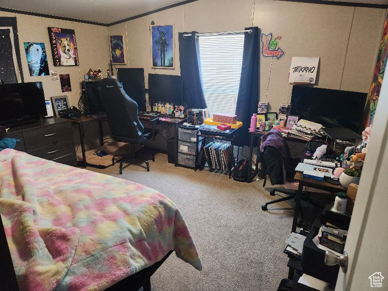 Carpeted bedroom with a desk, ornamental molding, and vaulted ceiling