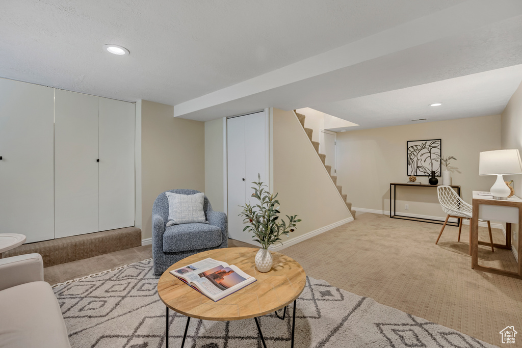 Living room featuring light carpet, recessed lighting, and stairs