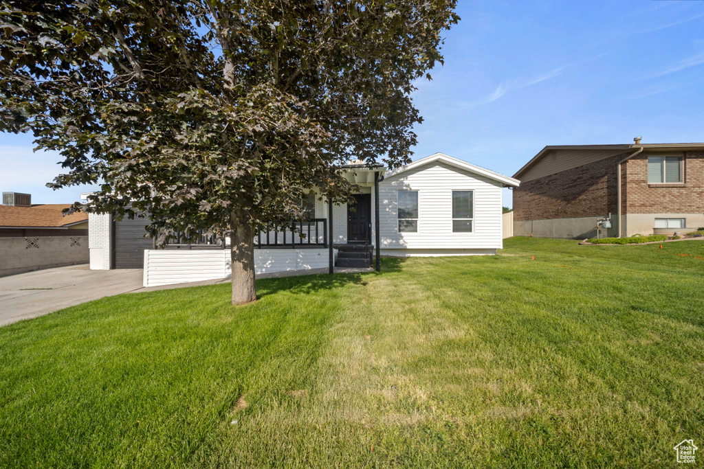 View of front of home with a front yard, a garage, and concrete driveway