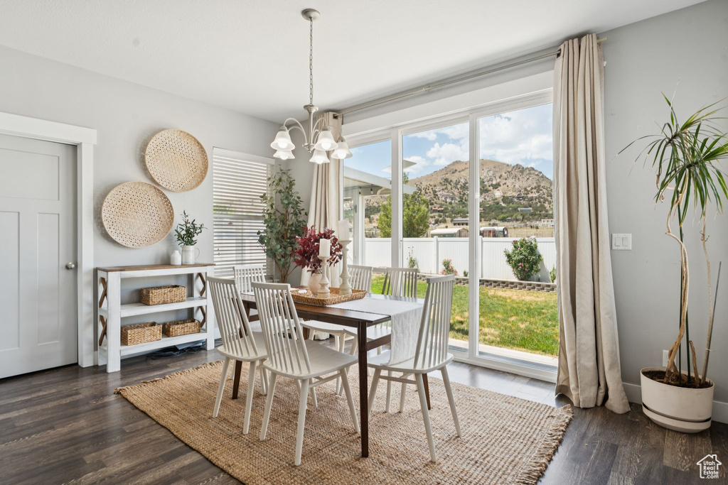 Dining area with a mountain view, a chandelier, and dark wood-type flooring