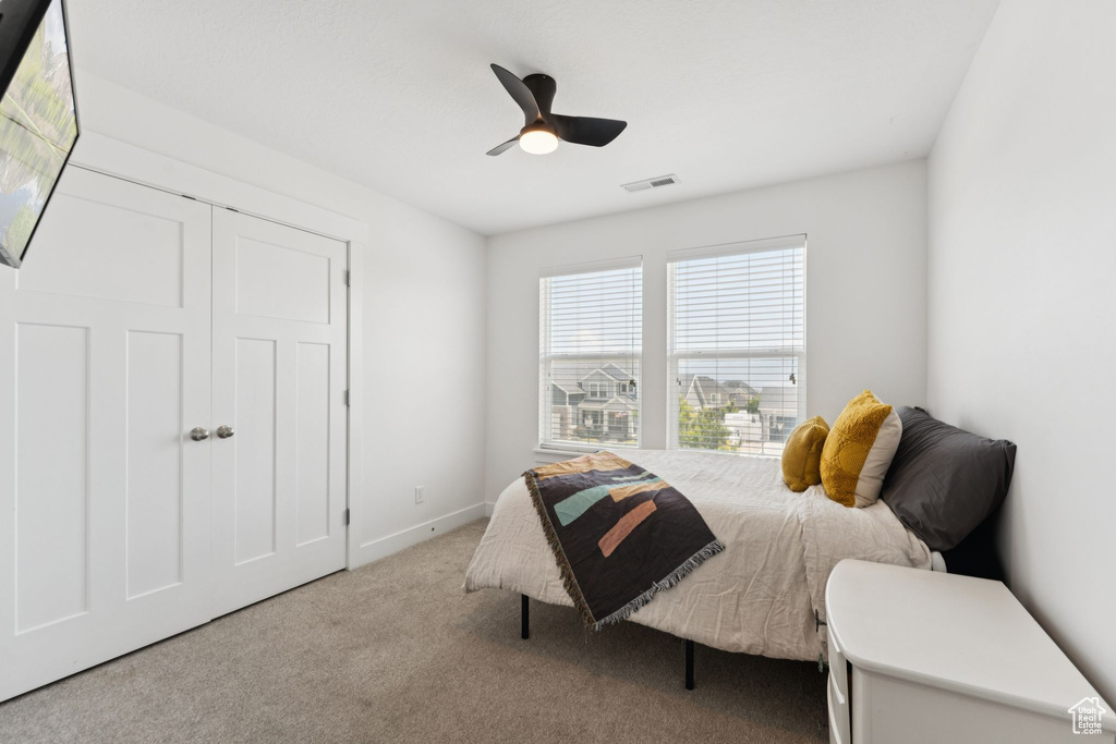 Carpeted bedroom with a ceiling fan and baseboards