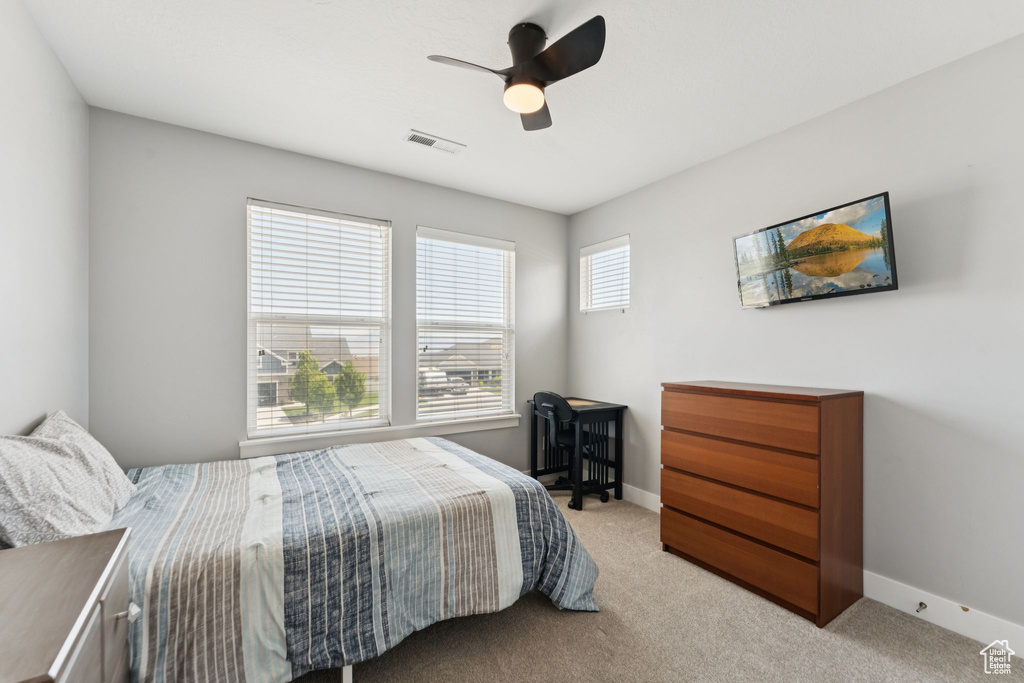 Bedroom with light colored carpet and ceiling fan