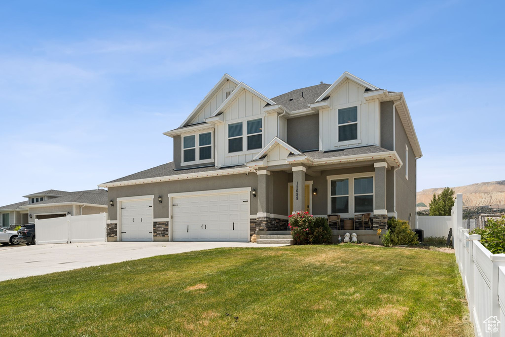 Craftsman-style home with a porch, board and batten siding, driveway, and stone siding