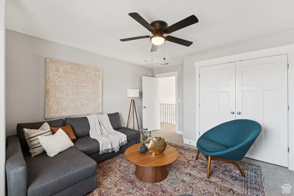 Living area with carpet flooring and ceiling fan