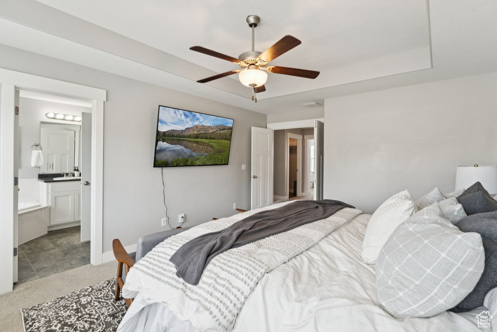 Bedroom with light carpet, ensuite bath, and ceiling fan