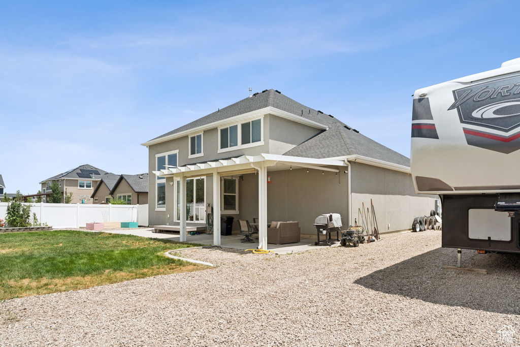 Rear view of house with a pergola, stucco siding, a patio, and roof with shingles