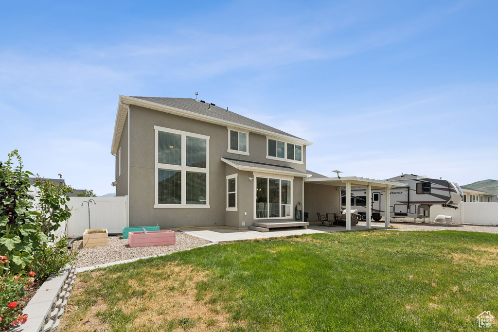Rear view of house with a patio area, a fenced backyard, stucco siding, and a pergola