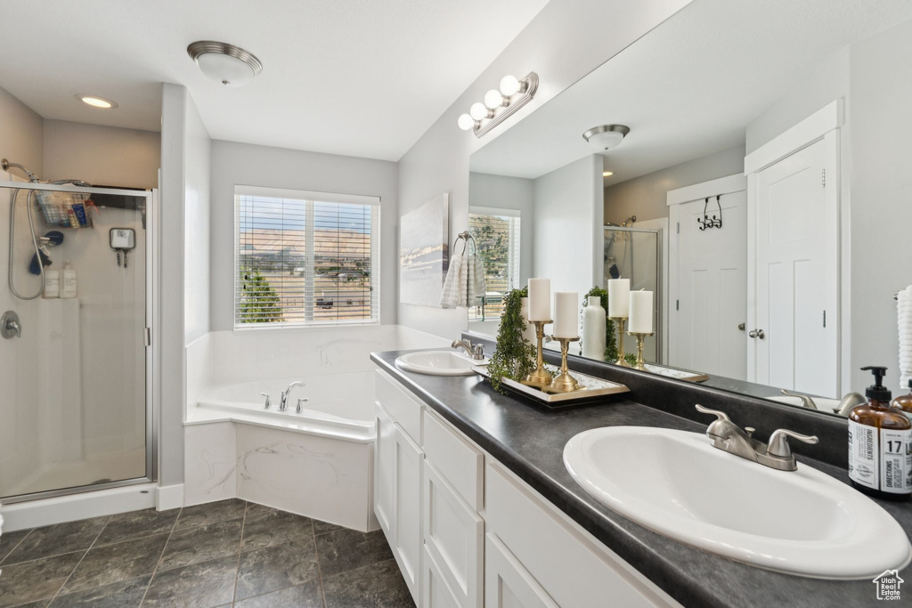 Bathroom featuring a garden tub, a stall shower, and double vanity
