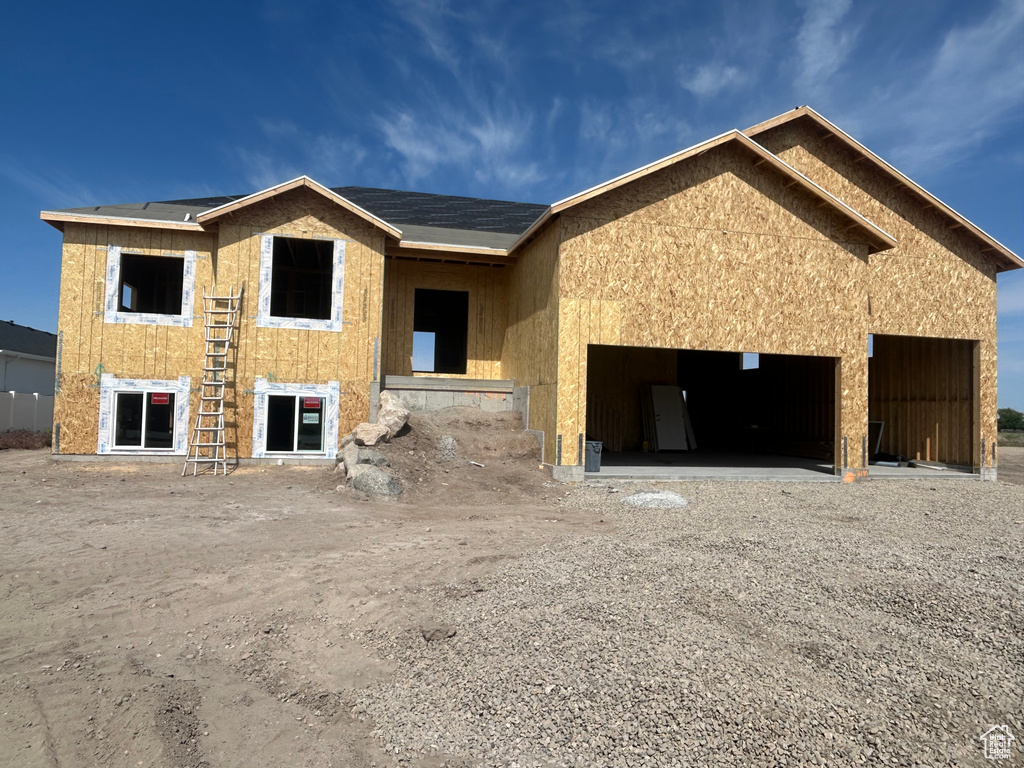 Unfinished property with an attached garage and driveway
