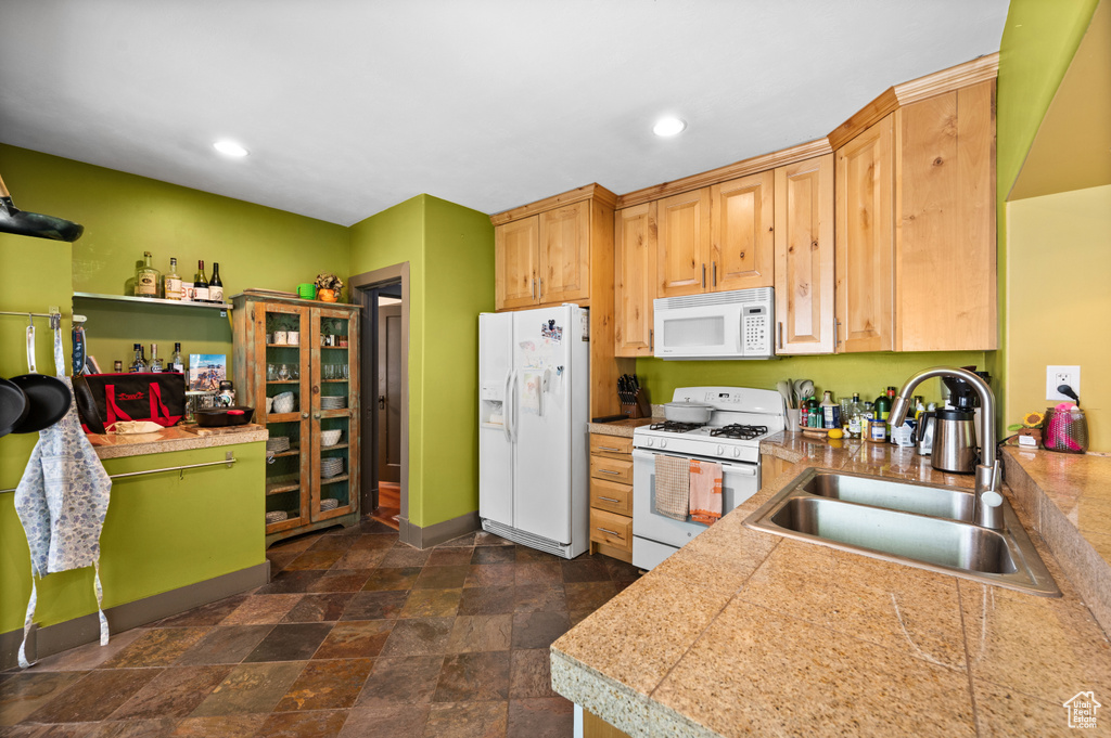 Kitchen with white appliances, tile countertops, stone finish flooring, and recessed lighting