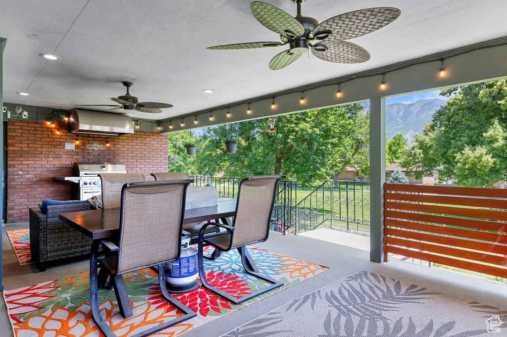 Wooden deck featuring ceiling fan, outdoor dining space, and area for grilling
