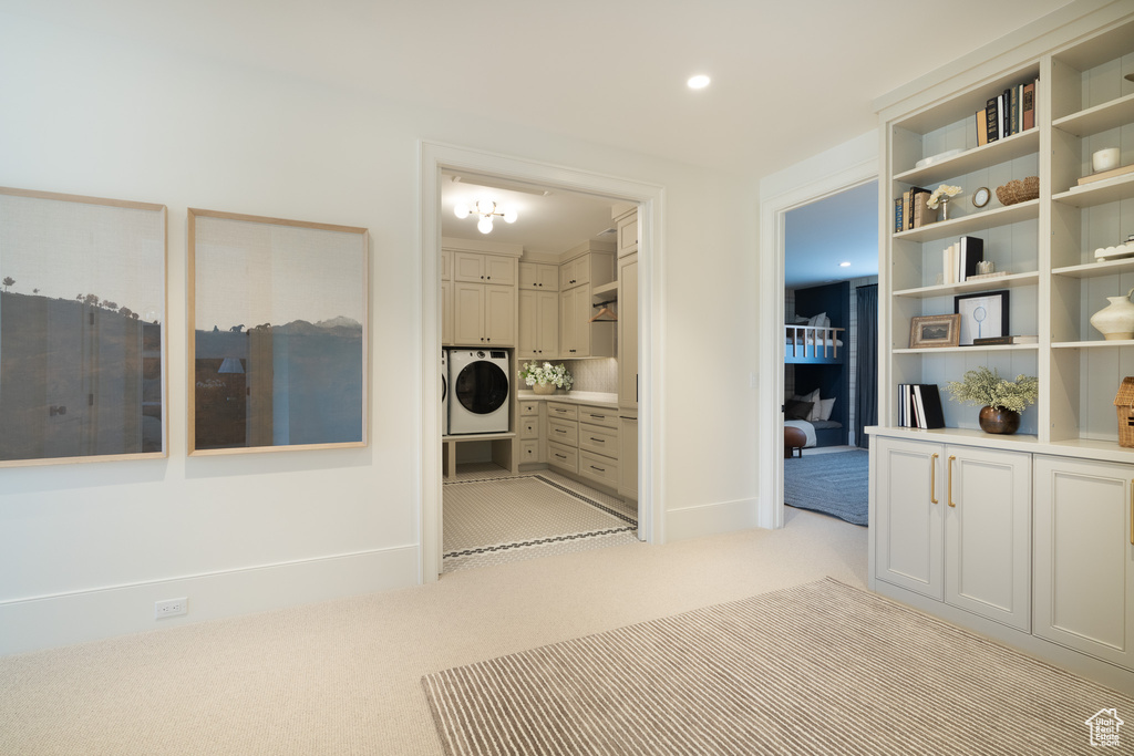 Corridor featuring washer / dryer and light colored carpet