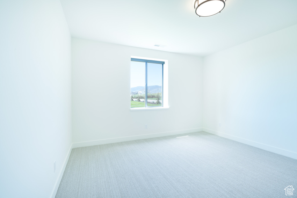 Carpeted empty room with baseboards