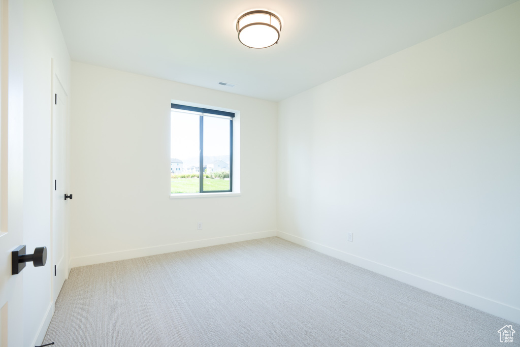 Carpeted empty room with baseboards
