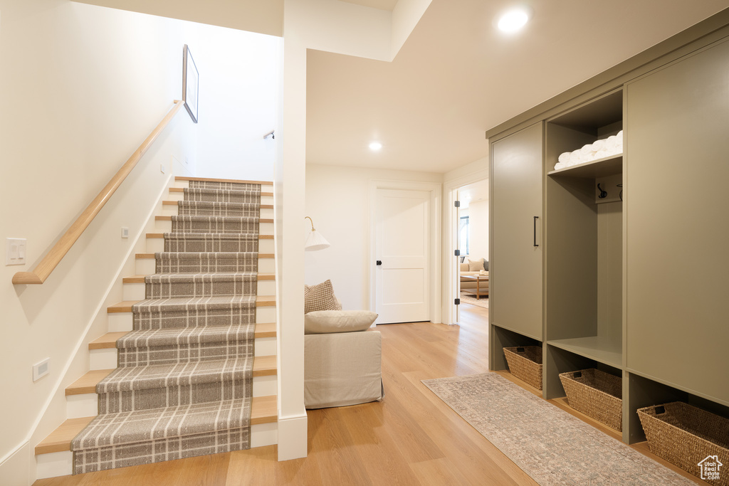 Staircase featuring wood finished floors and recessed lighting