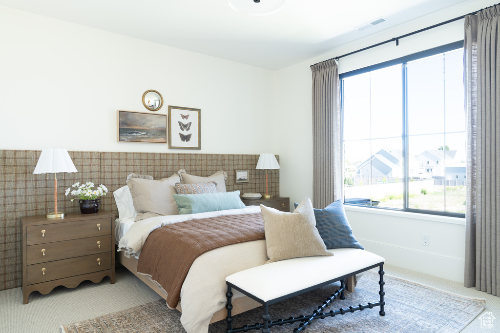 Carpeted bedroom featuring multiple windows