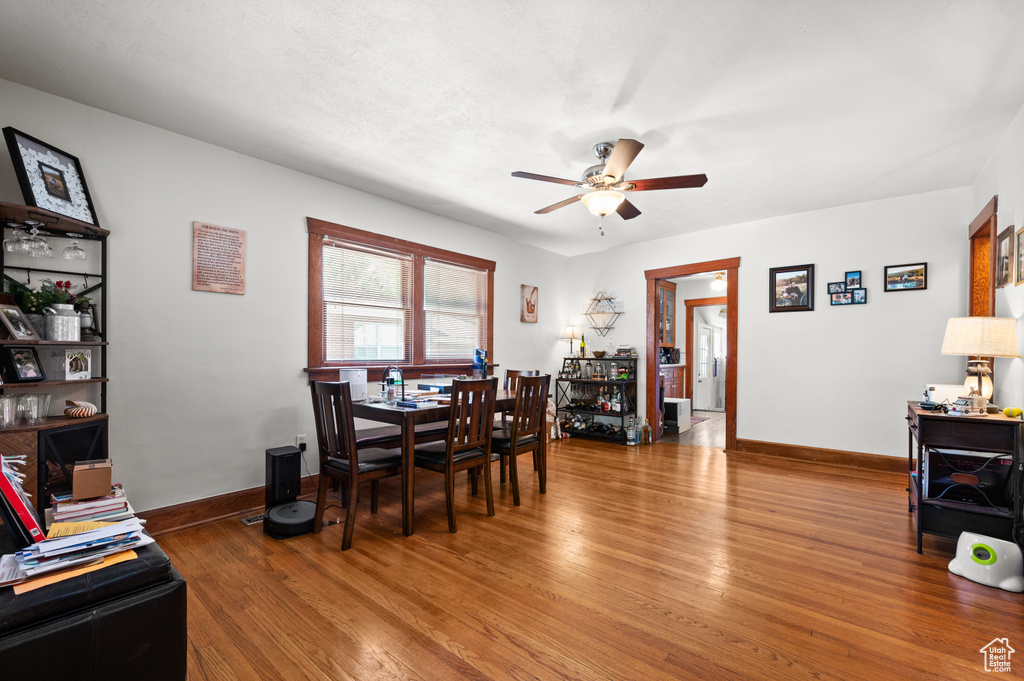 Dining space with a ceiling fan and wood finished floors