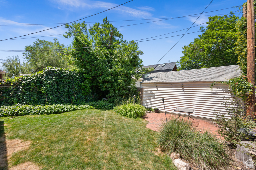View of grassy yard featuring a patio