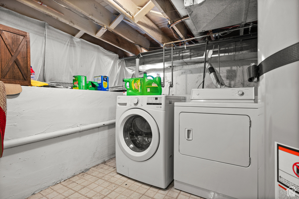 Washroom with washer and dryer and light floors