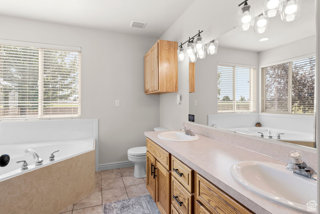 Full bath with a garden tub, double vanity, plenty of natural light, and tile patterned floors