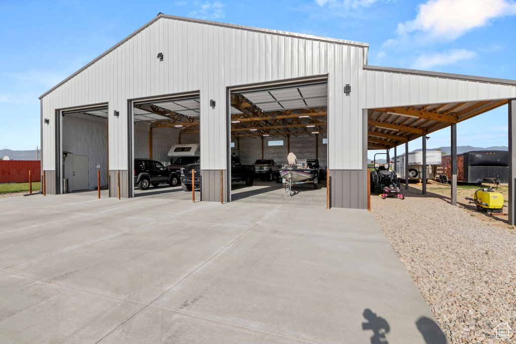View of outdoor structure featuring concrete driveway