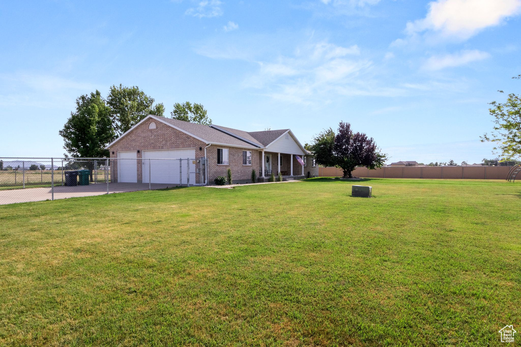 Single story home featuring concrete driveway, a garage, brick siding, and a gate