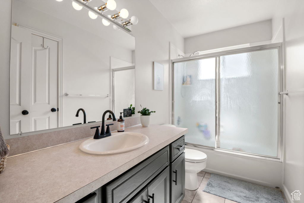 Bathroom with vanity, enclosed tub / shower combo, and tile patterned floors
