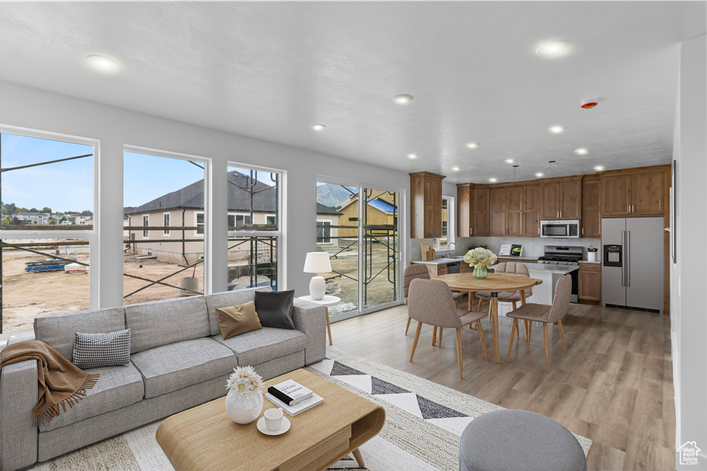 Living area with recessed lighting, plenty of natural light, and light wood-style flooring