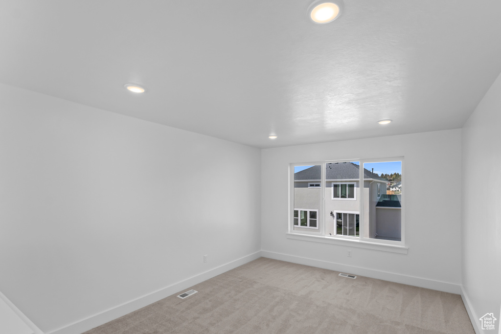 Spare room with light carpet and recessed lighting