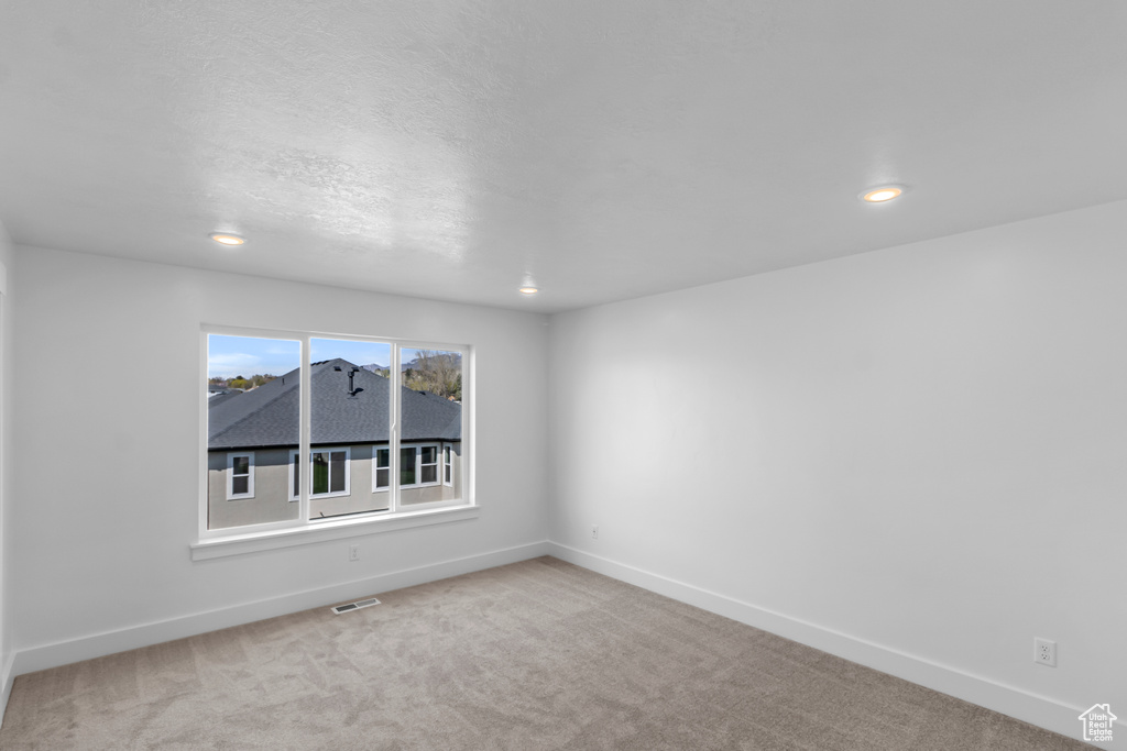 Empty room with carpet floors and recessed lighting