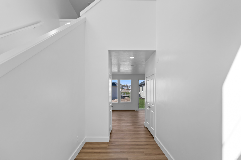 Hallway with wood finished floors and recessed lighting