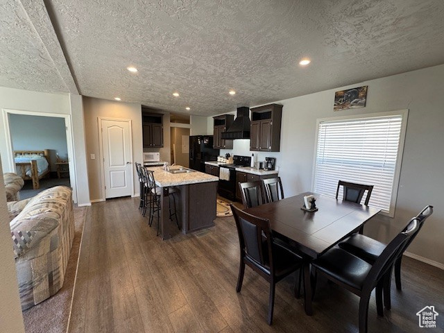 Dining area featuring dark wood finished floors, a textured ceiling, and recessed lighting