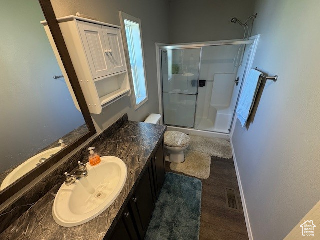 Full bathroom featuring a shower stall, vanity, and wood finished floors