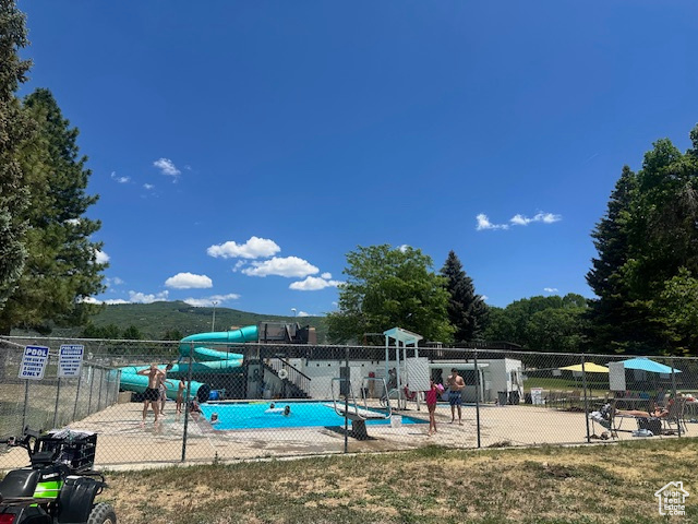 View of swimming pool with a water slide
