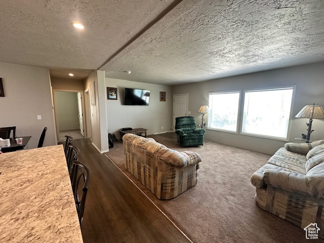 Living area featuring a textured ceiling, recessed lighting, and wood finished floors
