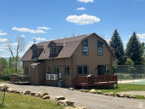 View of property exterior featuring a wooden deck